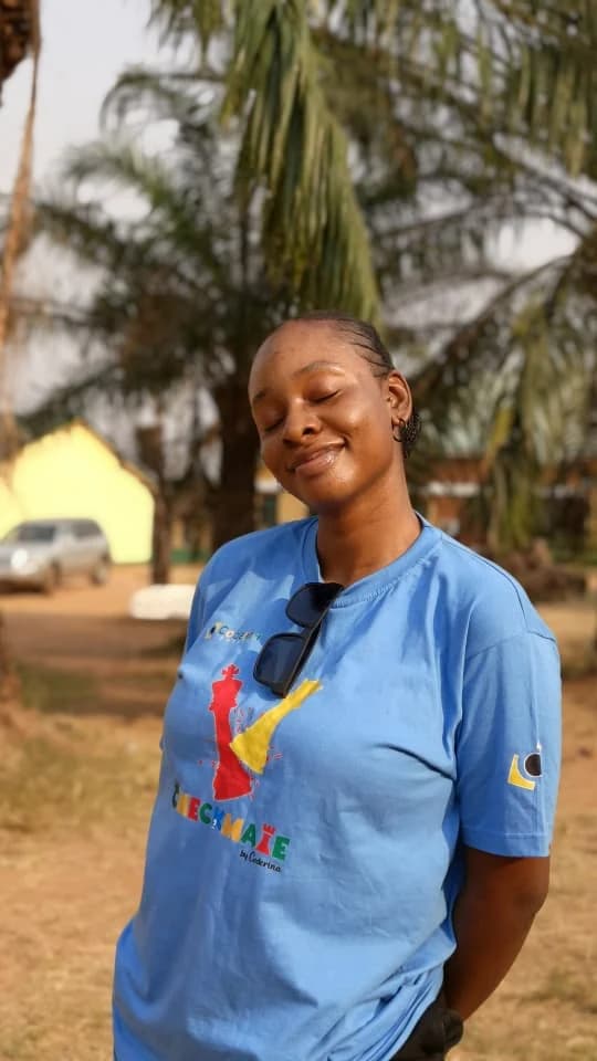Peace smiling with her eyes closed in a CHECKMATE T-shirt