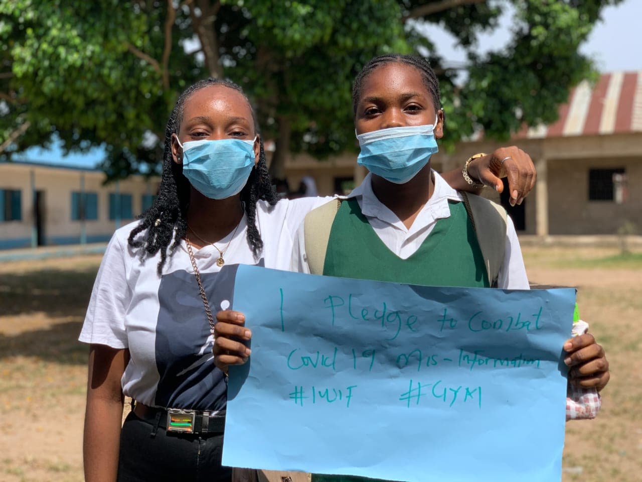 Peace with a student holding a pledge placard